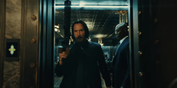 John Wick walking with a automatic shotgun.